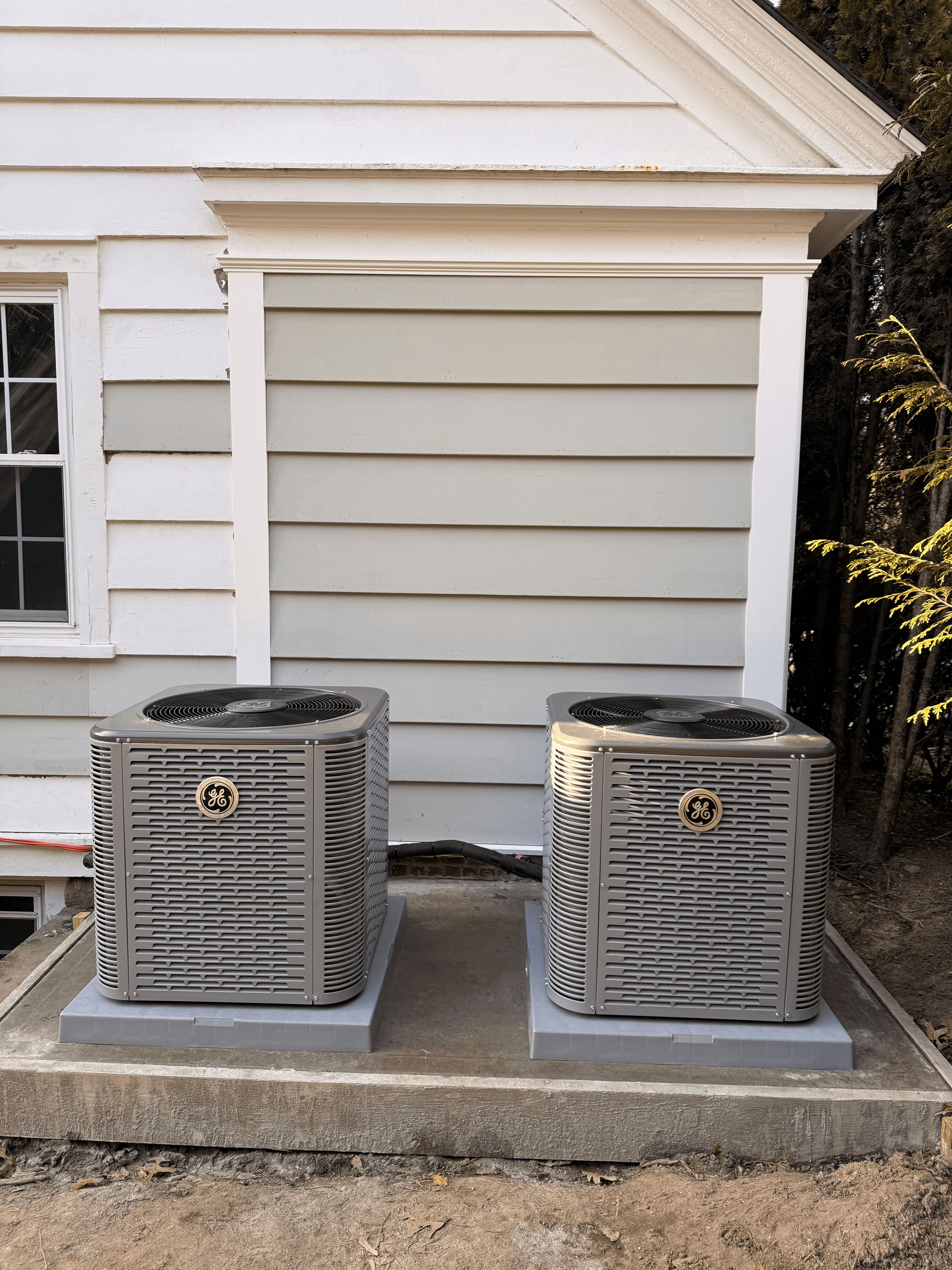 Dual GE AC condenser units installed on exterior concrete pad